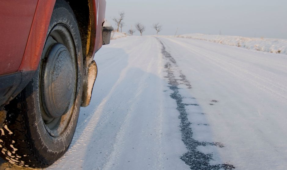 Pneu hiver monté sur une voiture roulant sur une route enneigée, ambiance montagne